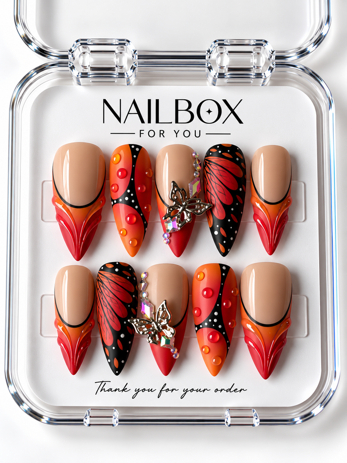 Monarch Flame nude, orange, and red press-on nails with black butterfly-wing patterns, white dots, raised droplets, and silver-tone butterfly charms in a clear nail box.