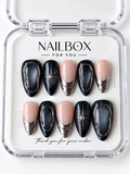 Midnight Orbit black and blush pink press-on nails with charcoal shimmer, silver-tone oval outlines, starbursts, and layered metallic French tips in a clear nail box.