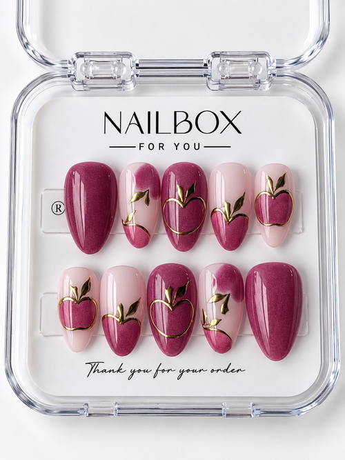 Berry Crush shimmering berry pink and blush press-on nails with apple motifs, gold-tone fruit outlines, metallic leaves, and curved accents in a clear nail box.