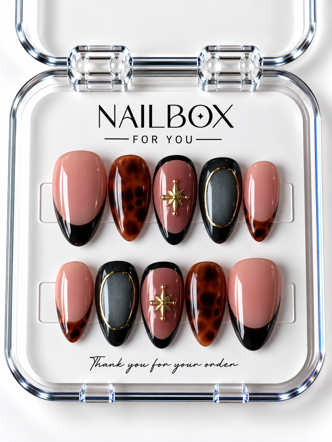 Tortoise Chic blush pink and black press-on nails with amber tortoiseshell patterns, charcoal shimmer, gold-tone oval frames, and starbursts in a clear nail box.