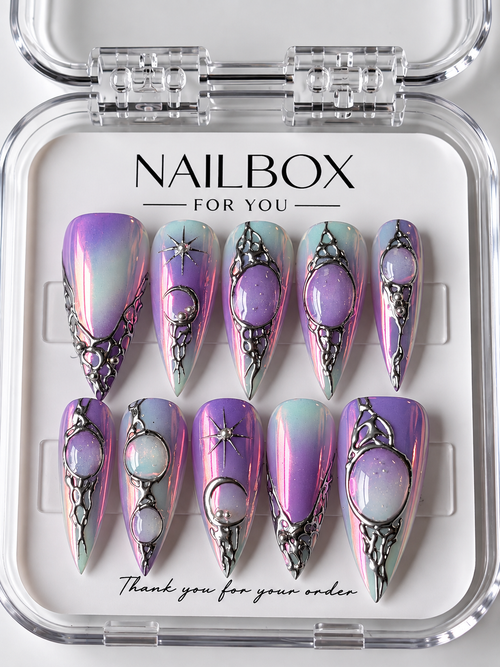 Aura iridescent purple and pink press-on nails with raised silver-tone frames, opalescent oval embellishments, and starbursts, displayed in a clear nail box.