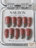 Silver Kiss dusty pink press-on nails with textured silver French tips, flowing metallic outlines and sparkling gems.