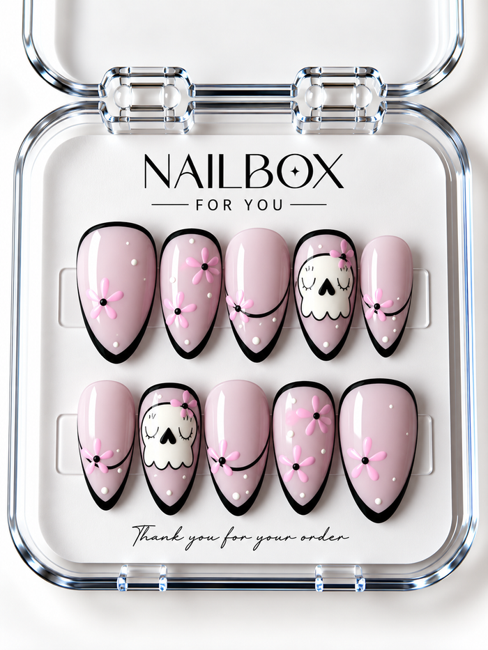 Boo in Bloom blush pink press-on nails with white ghosts, pink flowers, black outlined borders, curved French tips, and white dots in a clear nail box.