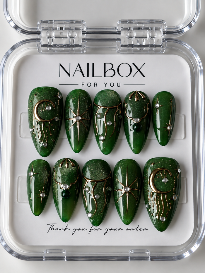 Emerald Moon shimmering green press-on nails with gold crescent moons, starbursts, flowing lines and pearl-like accents.