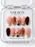 Wild Blossom blush pink press-on nails with raised peach flowers, red-and-black patterns, copper shimmer, gold-tone frames, and French tips in a clear nail box.