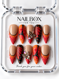 Monarch Flame nude, orange, and red press-on nails with black butterfly-wing patterns, white dots, raised droplets, and silver-tone butterfly charms in a clear nail box.