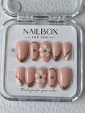 Golden Petals nude pink press-on nails with raised pearlescent white flowers, rose gold lattice tips and starburst accents.