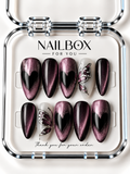 Dark Love black and plum-pink shimmer press-on nails with black hearts and milky white accent nails featuring silver-tone butterfly wings, displayed in a clear nail box.