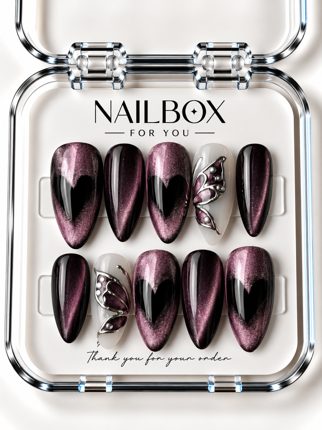 Dark Love black and plum-pink shimmer press-on nails with black hearts and milky white accent nails featuring silver-tone butterfly wings, displayed in a clear nail box.