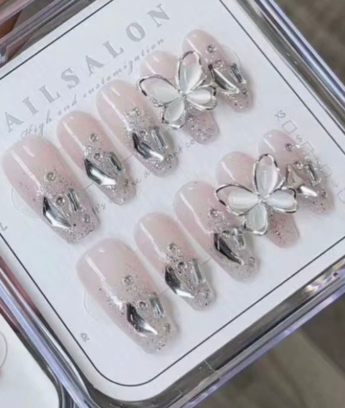 Silver butterfly press-on nails with chrome accents and 3D charms
